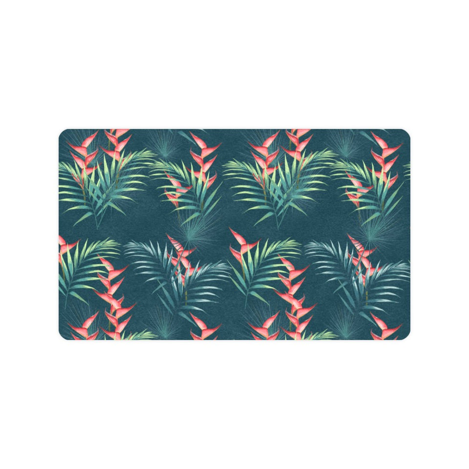 heliconia flowers, palm and monstera leaves on bla Doormat