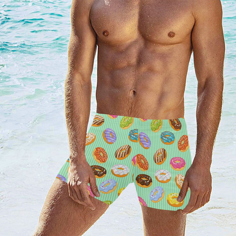 Colorful donut pattern green background Men's Swimming Trunks